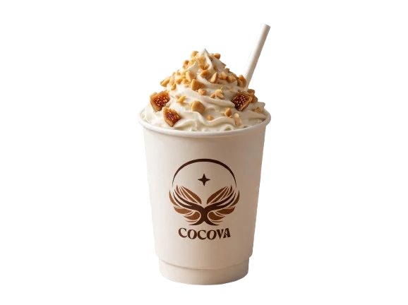 A Cocova kaju thick shake in a kraft cup, crowned with whipped cream and cashew pieces.